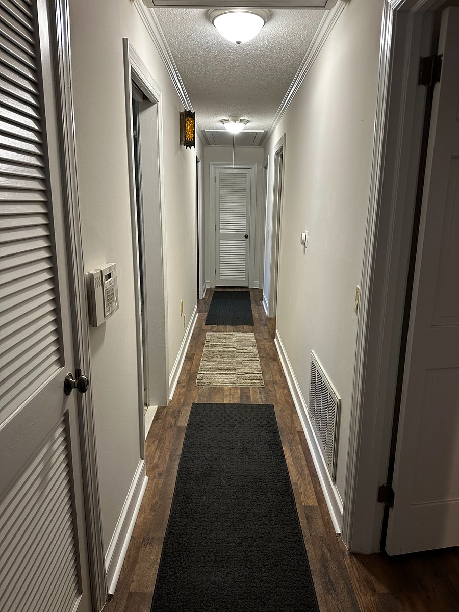 Hallway from den and living room leading to bedrooms.  First full bath is first door to the left and primarily used by guests in bedrooms to the right side of hall.  Master bedroom is at the end of the hall to the left and has a private bathroom.