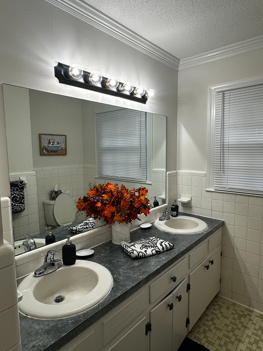 The hall bathroom features a double vanity with two sinks and large well lit mirror.  