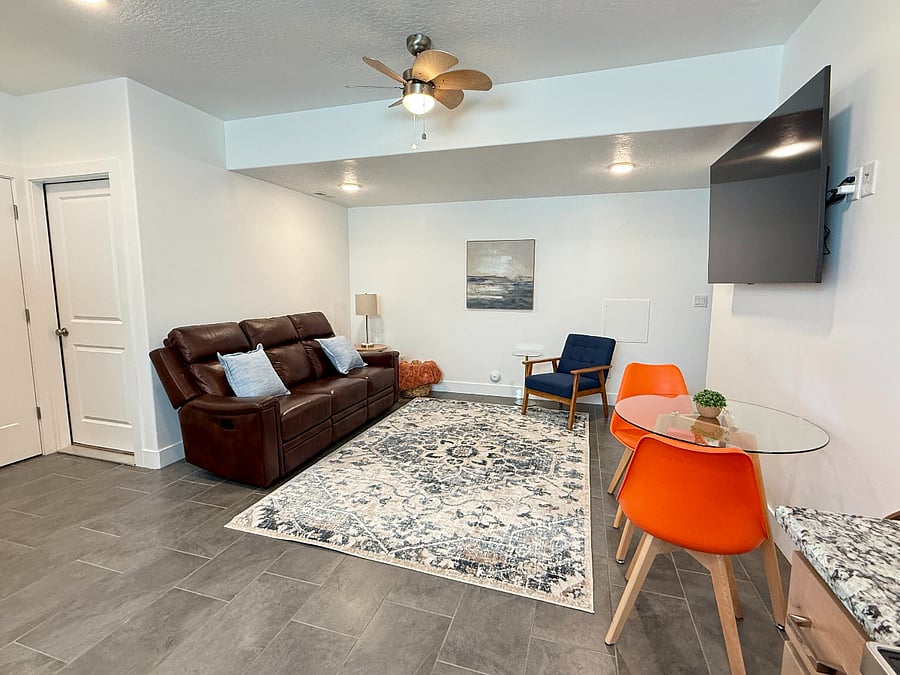 Inviting living area with a reclining leather sofa, TV, and dining space