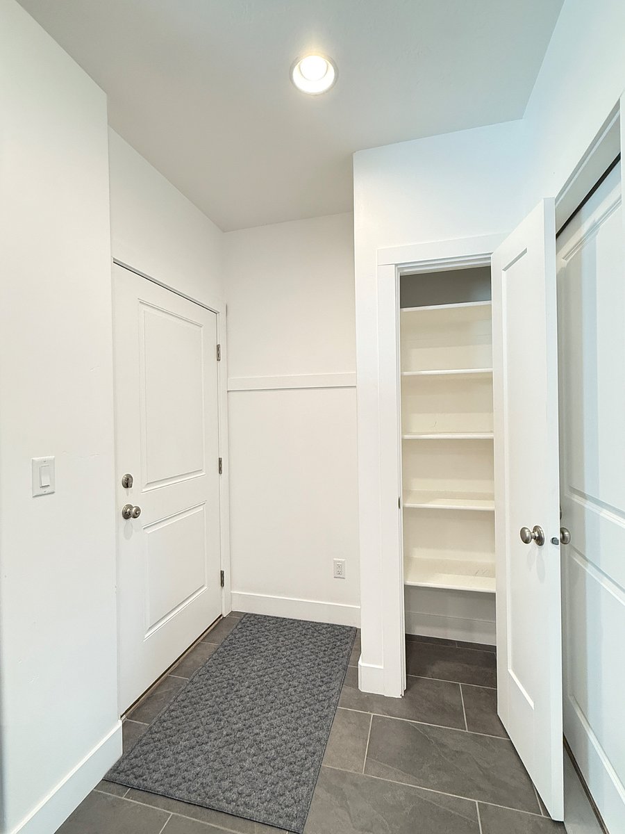 Convenient entryway closet with shelves perfect for extra food storage, pantry items, or personal belongings