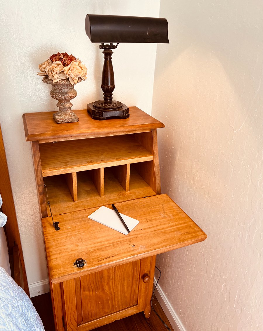 Secretary Desk with a flip-down surface that creates a cozy work area. A series of concealed compartments and a tidy drawer below provide just enough space for essentials, offering a dedicated nook for productivity.