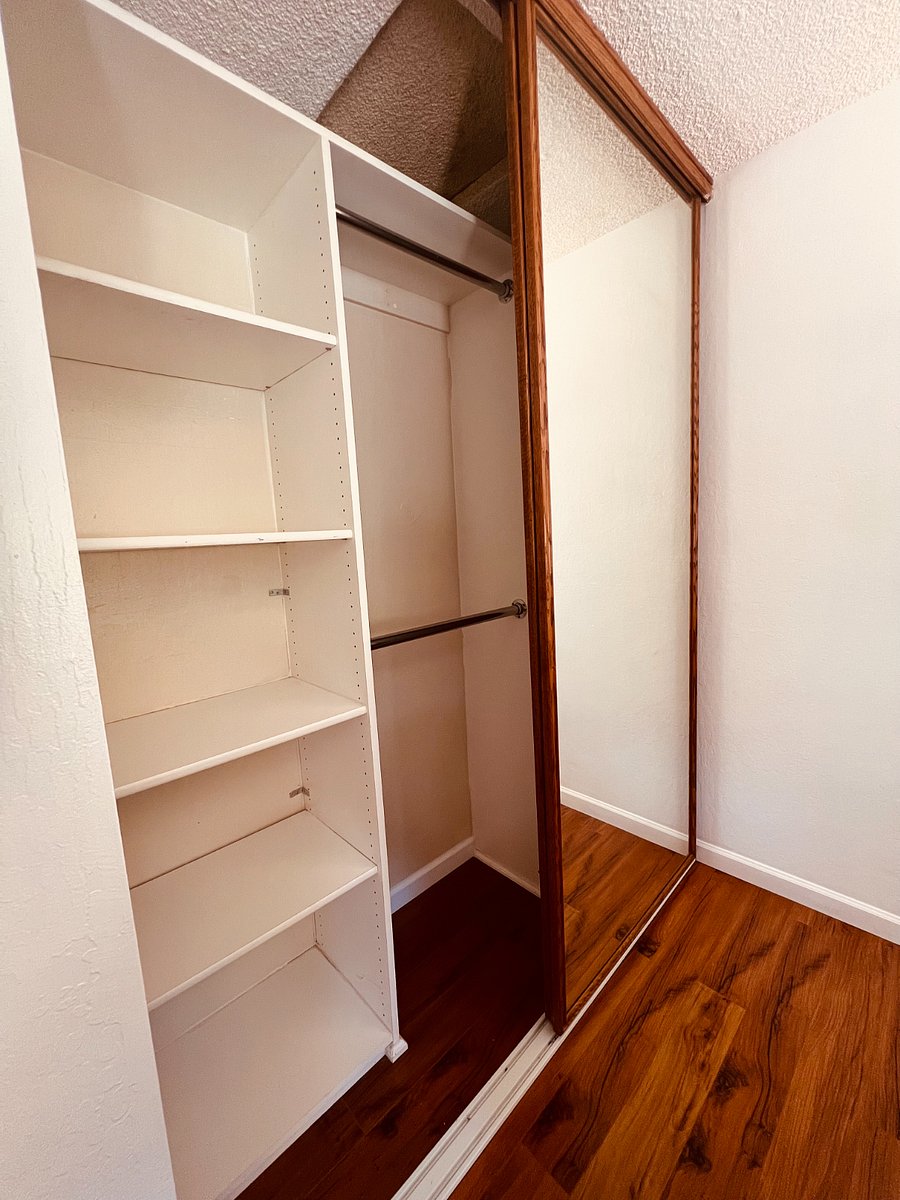 A wall closet with a versatile interior.  It has both a hanging bar for garments and dedicated shelving. This mixed-use design is perfect for travelers who need to unpack a variety of items, from suits and dresses to folded T-shirts and bags.  