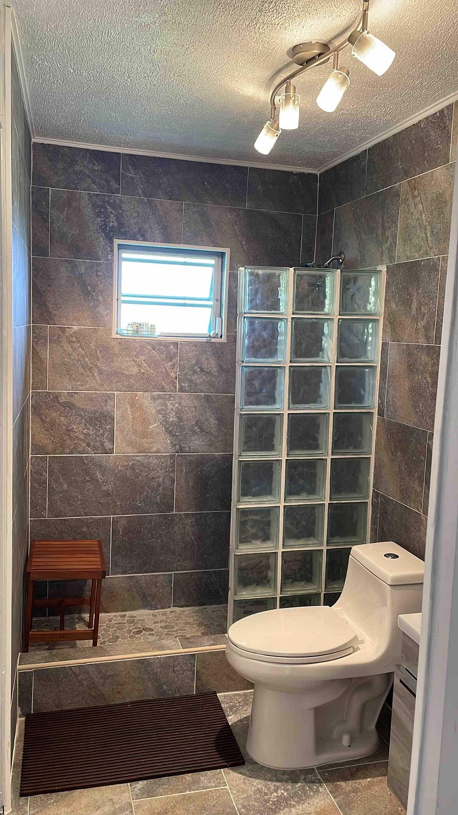 Rain shower with cistern water for refreshing guest experience, toiletries and towels provided, send us a message to ask about additional supplies for your travel group self-care needs