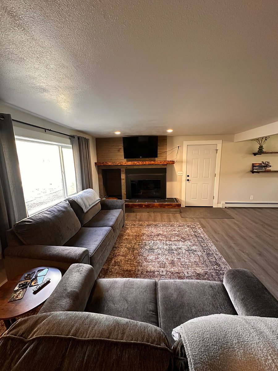 The living room with plenty of sunlight, has two couches and smart TV. 