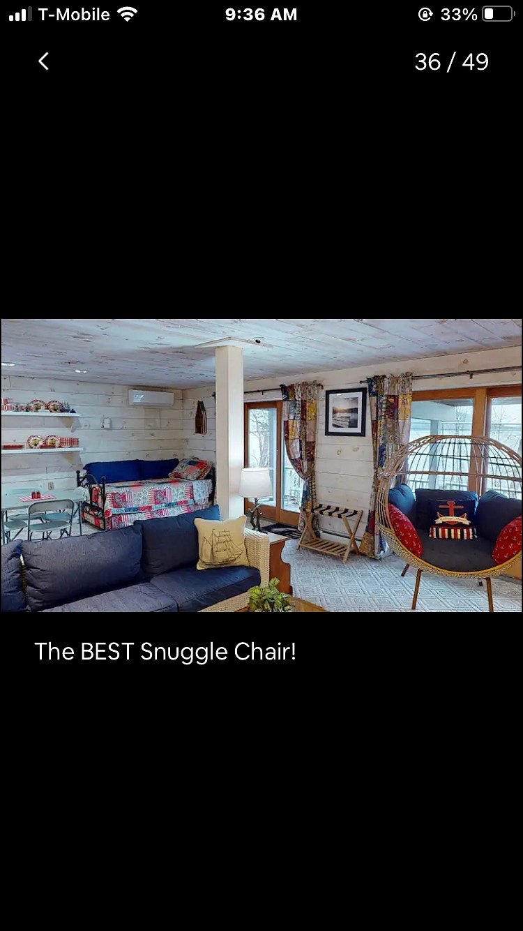 Long room with comfy egg chair and couch for watching TV.