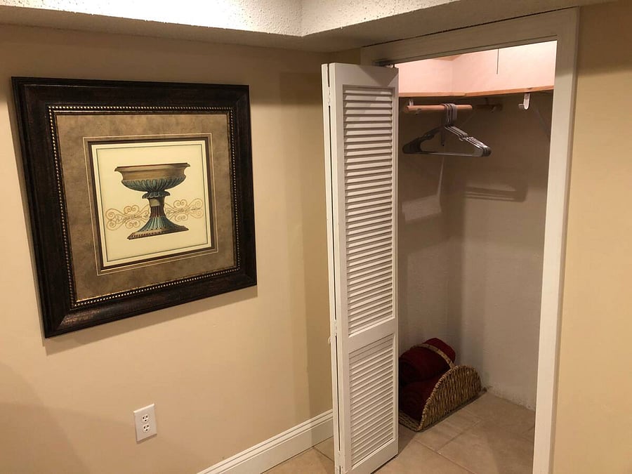 The closet in the living room has extra space to hang up clothes and jackets