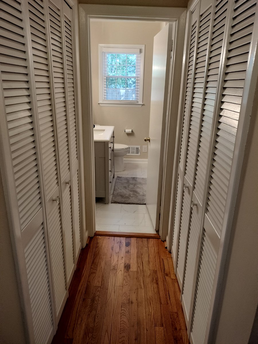 View from hallway into shared full bath (storage closets on both sides)