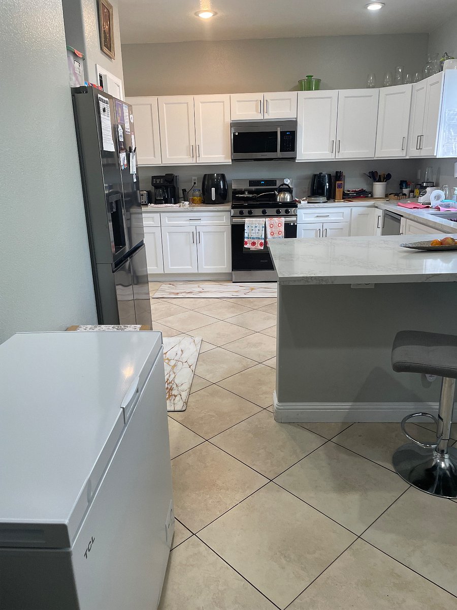 Another view of the kitchen with the stove, microwave, air air fryer, cabinet space & where there is extra dishes, plates, or can store food.