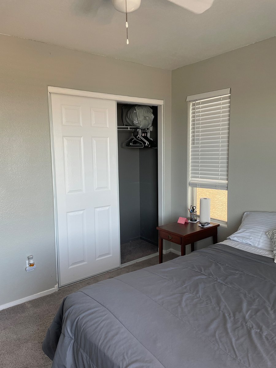 Bedroom number two with closet space and small shelving hanging in closet with hangers