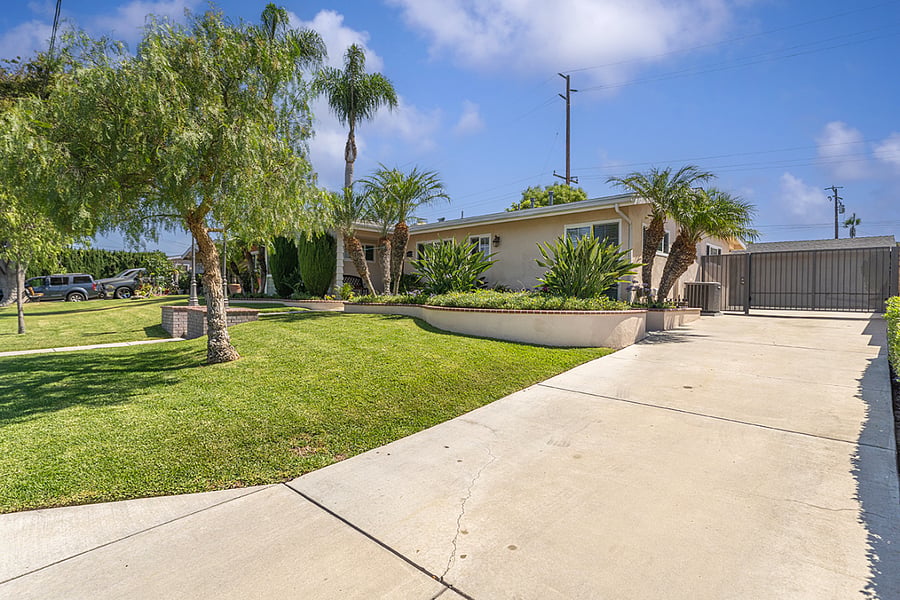 Driveway that branches off to a handicap ramp to the front porch and leads to the motorized entry gate to the backyard and garage.  