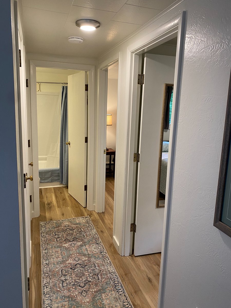 Hallway, coat and linen closets on the left, bedrooms on the right, bathroom at the end of the hallway