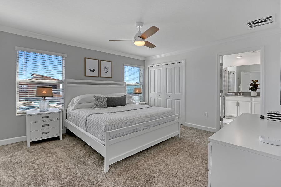 King bed with hotel-style linens and ample storage. 