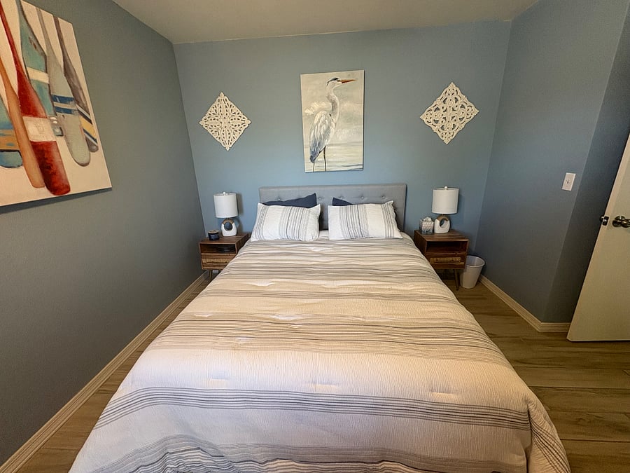 1st guest bedroom with queen bed and desk area
