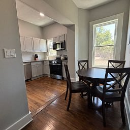 Modern kitchen featuring a dining nook and hardwood floors.
