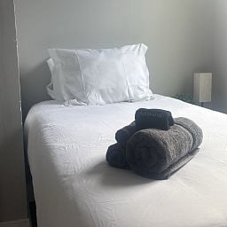 Bedroom featuring a twin bed with freshly laundered linens and towels.