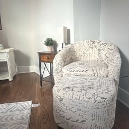 Cozy seating area featuring an accent chair with a matching ottoman.