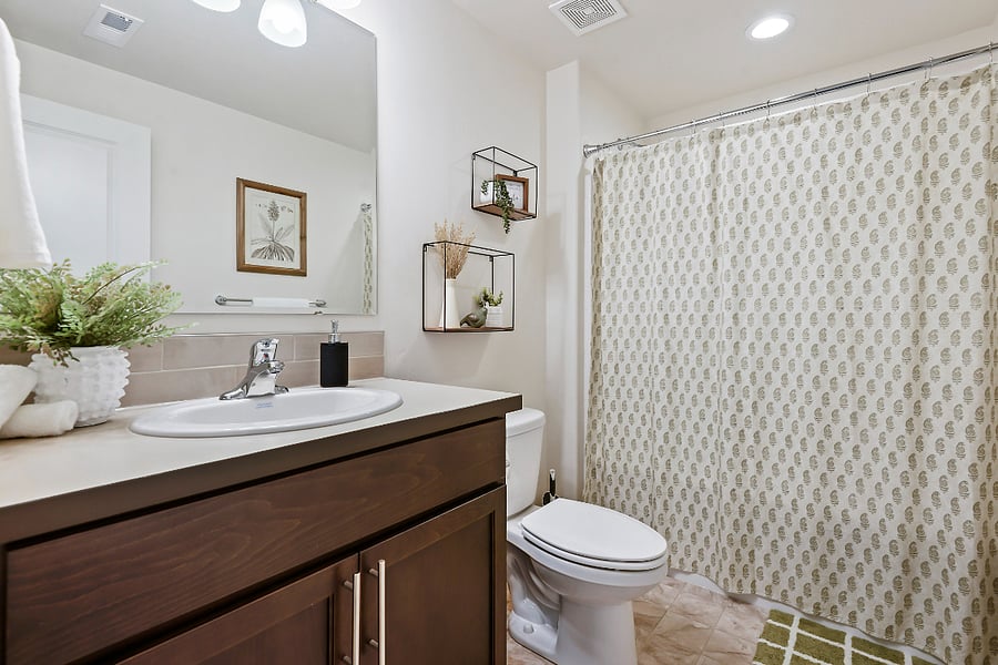 guest bathroom with bathtub, hair dryer, white towels, shampoo and conditioner