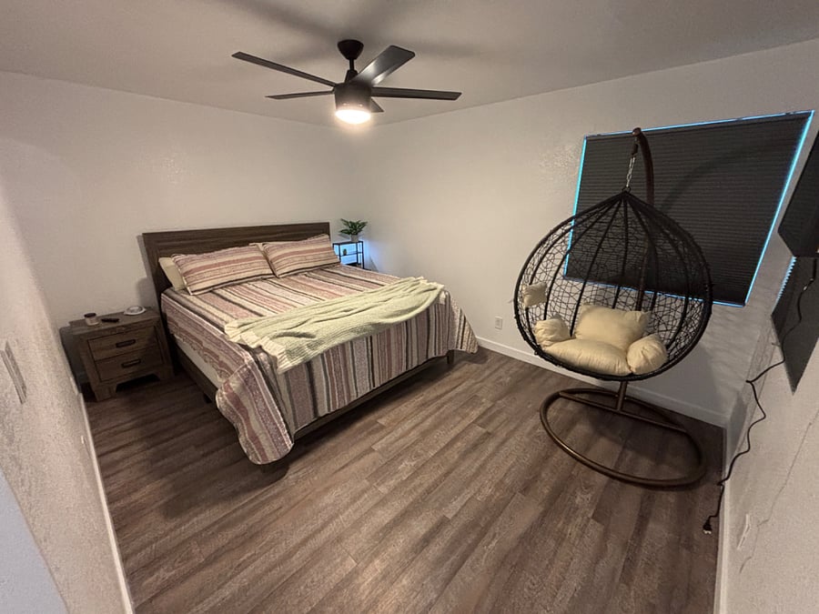 Primary Bedroom has a king bed with closet, dressers, egg chair and mounted smart TV.