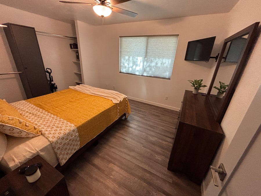 Bedroom 2 has a queen bed with closet, dressers and mounted smart TV.