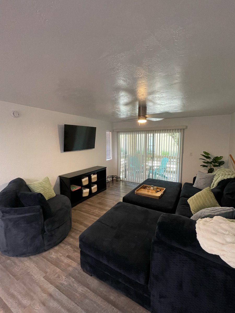 Comfy, cozy family room with plenty of seating, modern decor and mounted smart TV.
