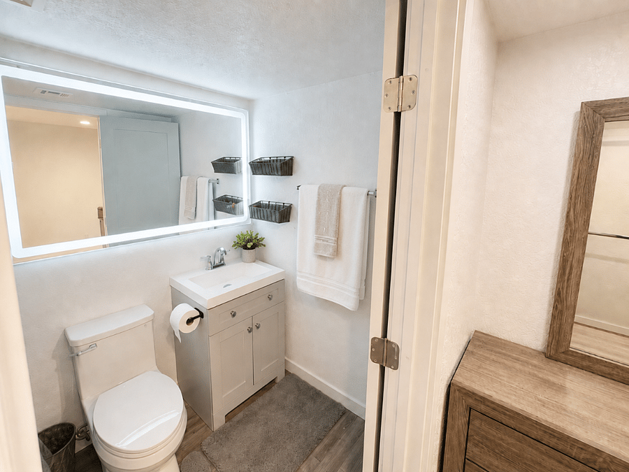 A bright, polished ensuite with a spacious vanity, illuminated mirror, walk-in shower, and thoughtful finishing touches that make the morning routine feel calm and easy.