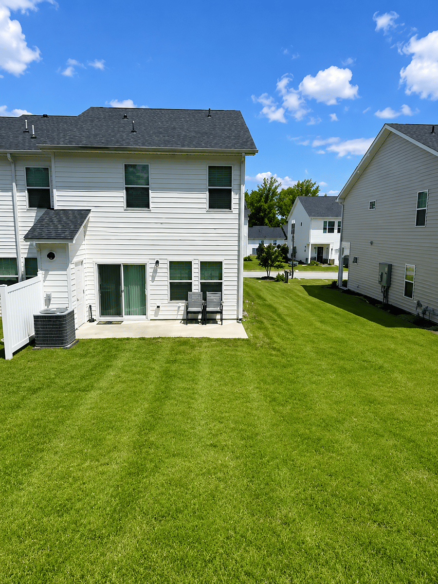 Large grassy green space behind the townhome