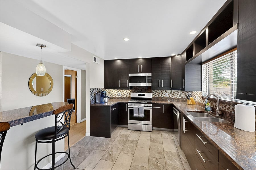 Spacious kitchen with granite counters, upgraded appliances, lots of cabinet space, bar seating