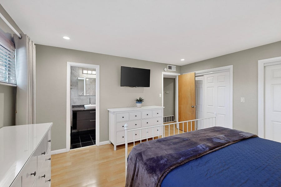 Primary bedroom with king bed, double closet, Smart TV, attached bathroom