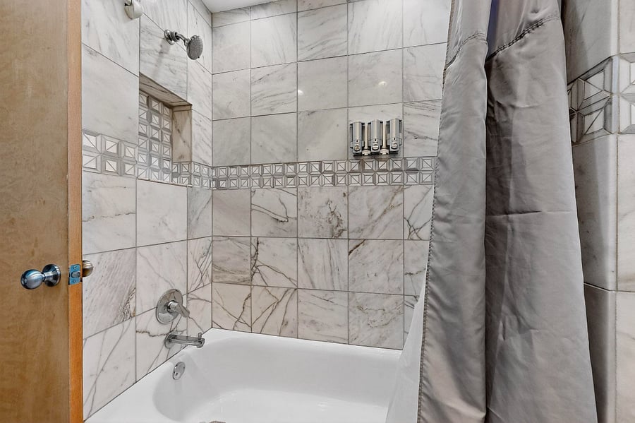 Hallway bathroom with tile shower, double sink vanity
