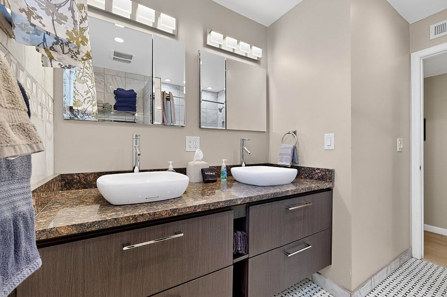 Hallway bathroom with tile shower, double sink vanity