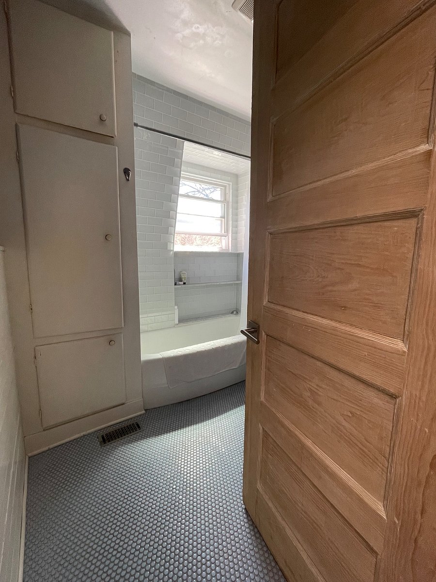 Penny tiled floor and glass subway tiled shower/bath.