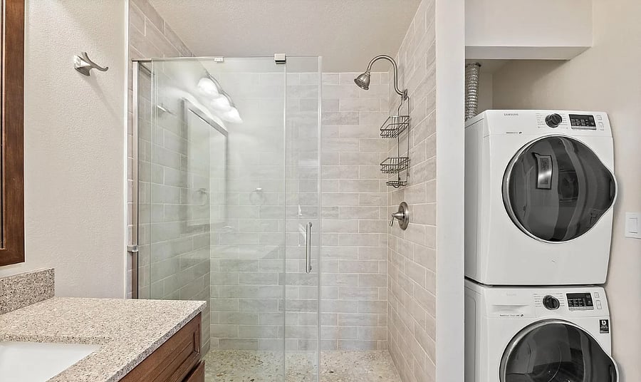 Bathroom with large shower and modern washer and dryer