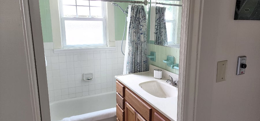 Full bath with shower and tub overlooking private backyard