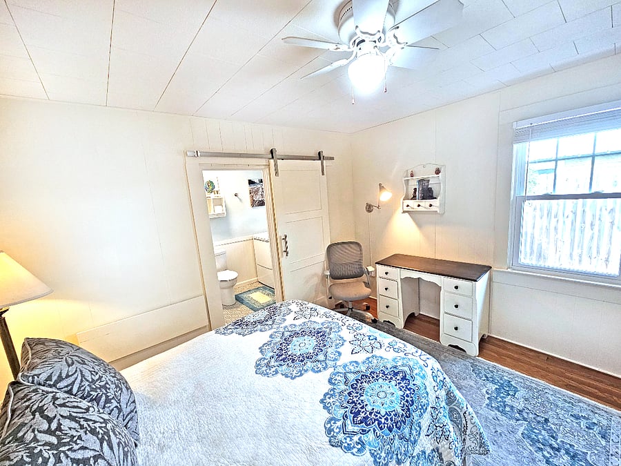 Second bedroom with full-sized bed, workspace, and half bath