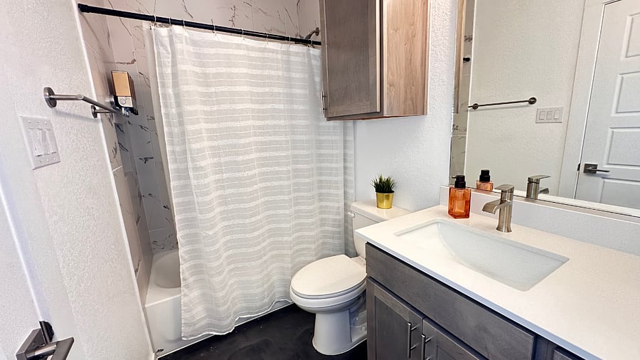 1st floor full bathroom features tub/shower, dimmable vanity lights, a shower fan, and extra cabinets for storage.