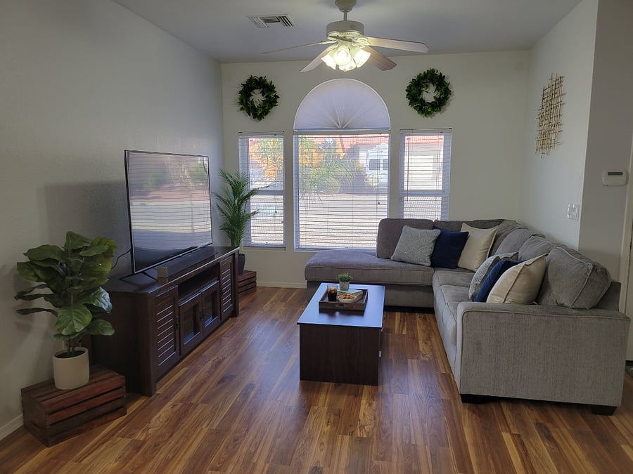 Living room with sectional couch and 65 inch smart TV. 