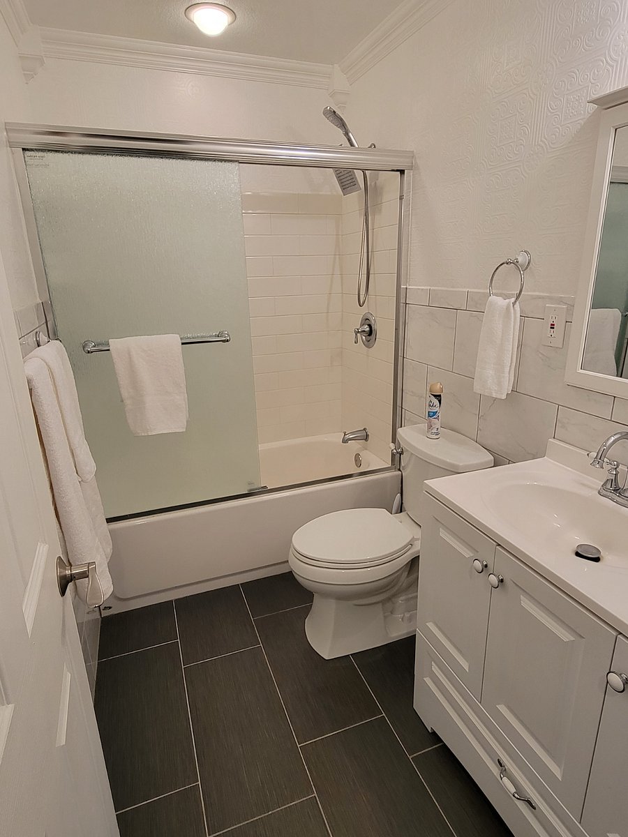 Second bathroom with tub/shower, vanity with storage and bonus storage behind the mirror as well. 
