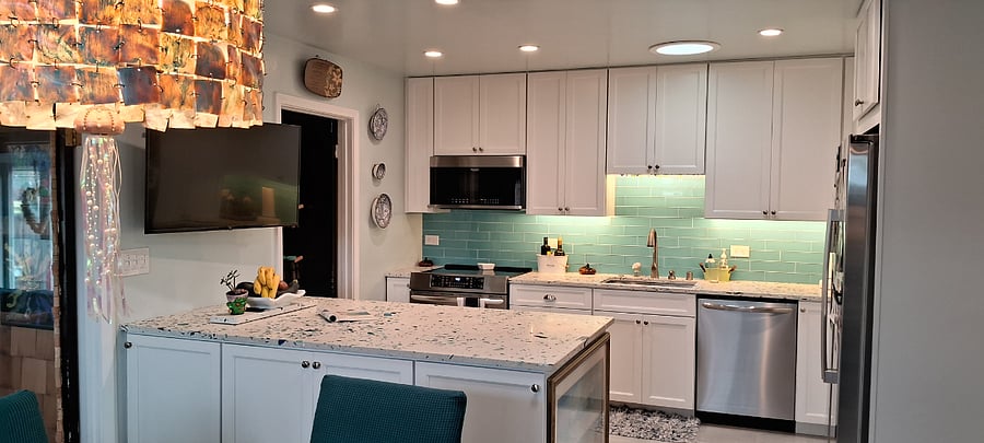 Our home recently went through a massive remodel- design: upgraded electrical, plumbing, and flooring and en entirely new kitchen! These counters were custom-made in Chicago and flown here, after adding a VERY special touch.... Sea glass that we collected over the years is embedded into the countertops! The gorgeous countertops are sustainable, durable, and a huge highlight of our bright and sunny kitchen. Stainless steel gourmet appliances include an induction range w/ built-in air fryer, over the range microwave, a side by side Bosch fridge, and a whisper-quiet dishwasher. The enormous island has tons of counter space for flowers, bowls of fresh fruit and of course, meal prep, as well as tons of storage in the cabinets, below. Also, there is a large walk-in pantry in the kitchen.