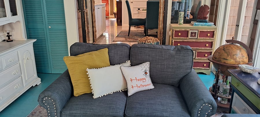 Another view of the warm & inviting sunroom. It has lots of comfy seating and a super cool collection of books about the ocean and living by the sea, sea glass, shells and driftwood in the display case. All collected here at Miramar Beach over the last 20+ years!