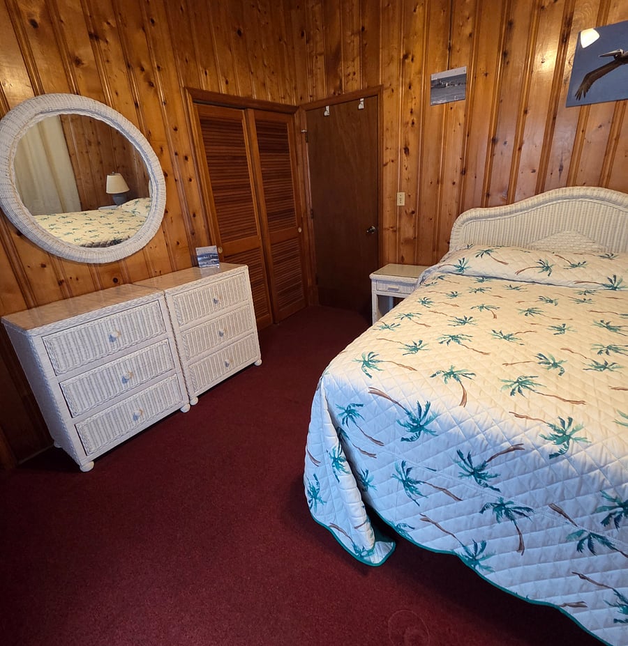 Bedroom 1 has white wicker furniture and queen size bed. 