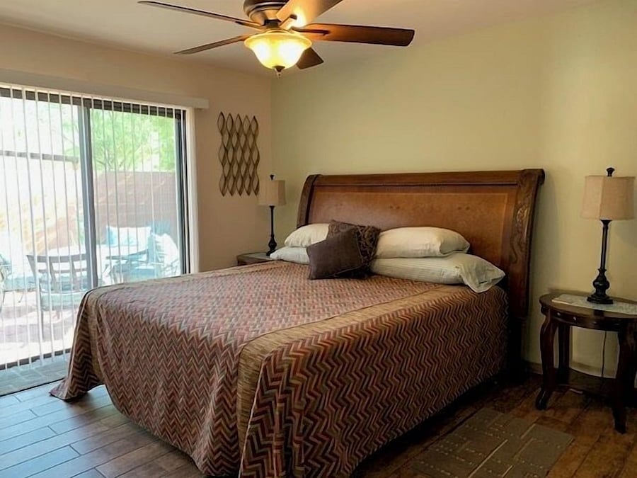 Ensuite bedroom, king bed, sliding glass door leads to walled in backyard.
