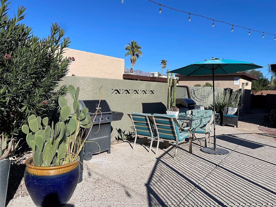 Outdoor dining near grills and pool.
