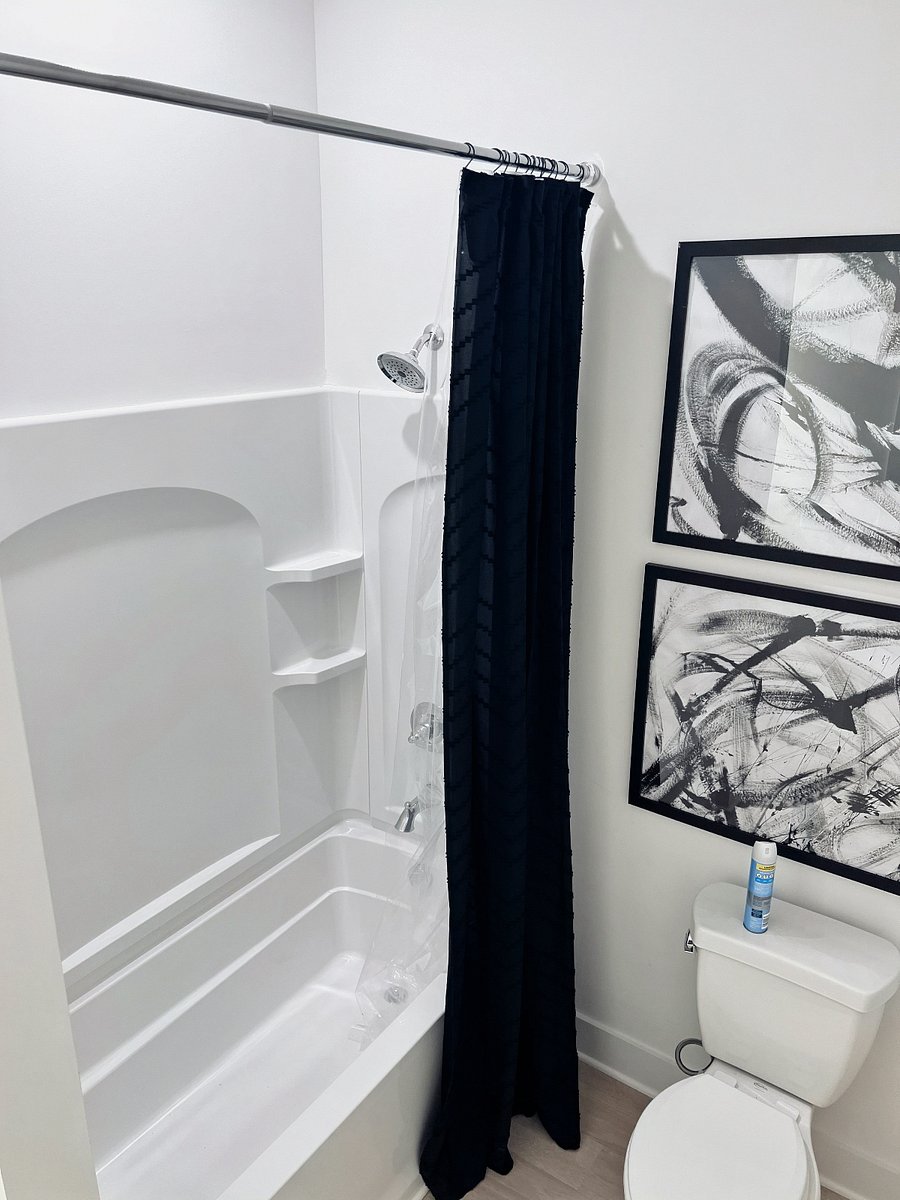 Bright, modern full bathroom with a tub/shower combo and stylish monochrome dcor.