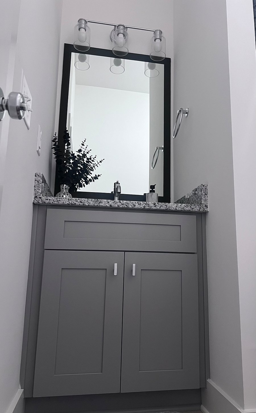 Sleek granite-top vanity with ample storage and modern lighting.