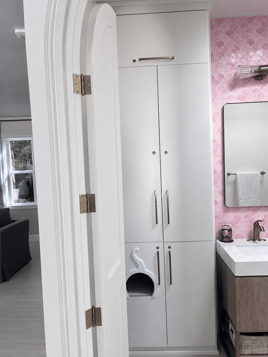 Thoughtfully designed bathroom storage includes extensive built-in cabinetry and a discreet cat-friendly litter-box cabinet with an adorable custom entryway.