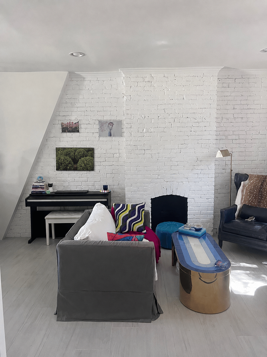 Beautiful original brickwork, a decorative fireplace, piano, and flexible seating create a character-filled living space that feels both stylish and comfortable.