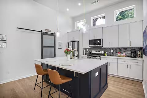 Kitchen and island. Door to pantry in the background.