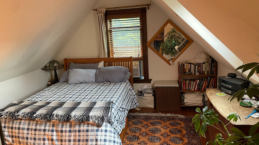 Primary bedroom in loft is open to space below but has a folding privacy screen.