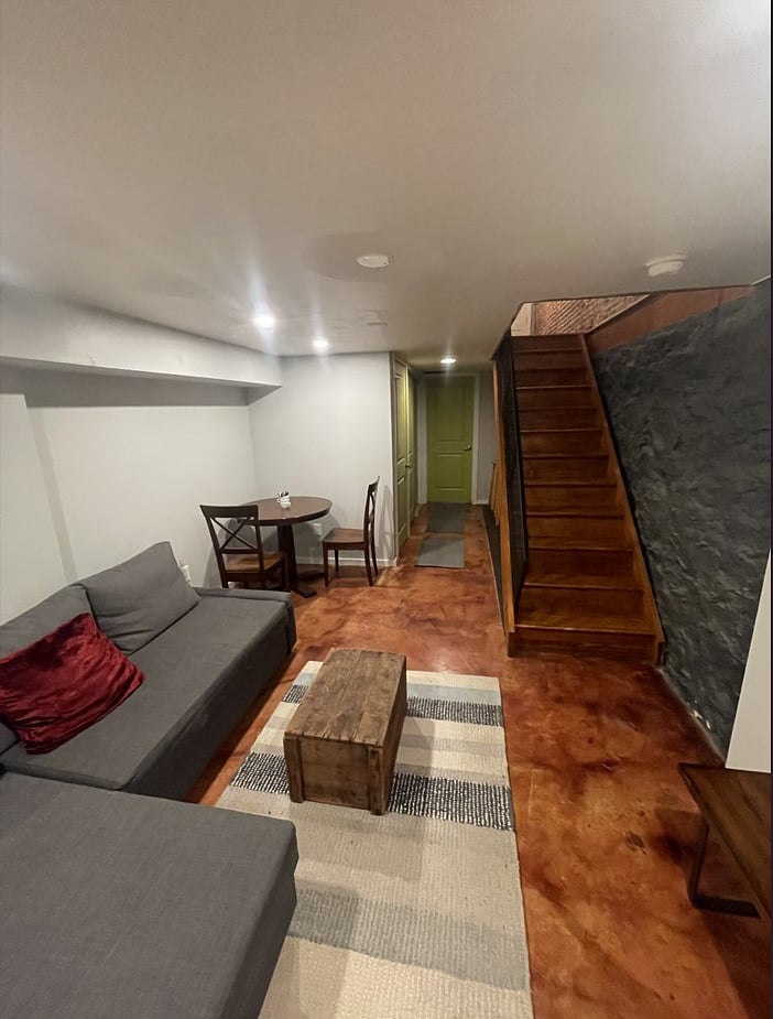 Basement common area with a fold out couch and full bath