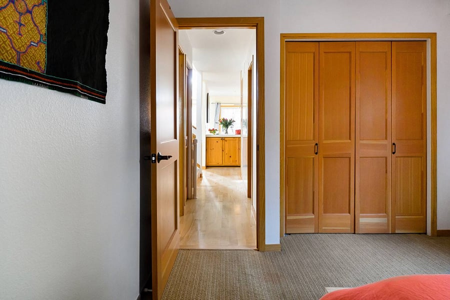 Primary bedroom off of hallway leading to kitchen and living room